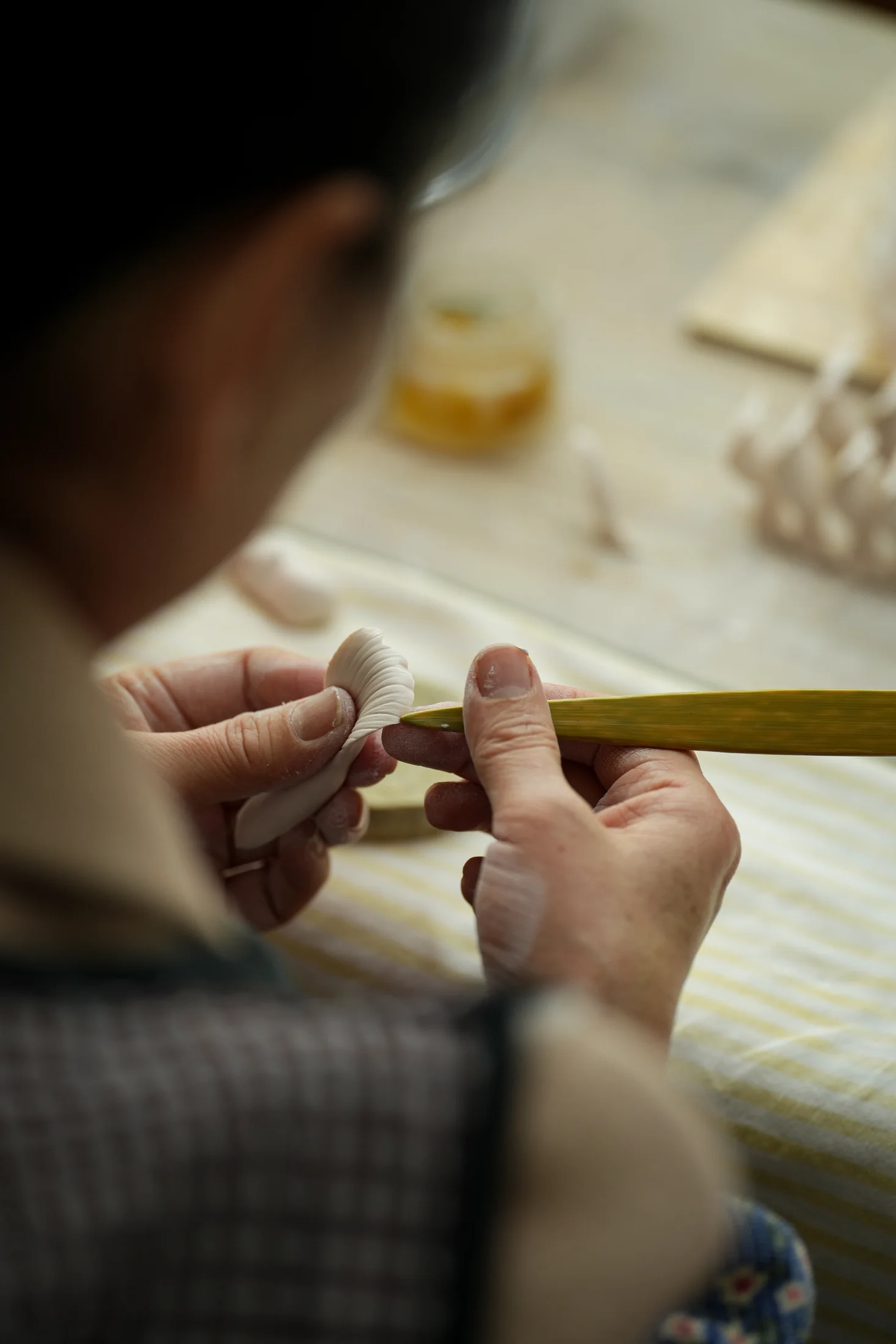 Artisan shaping a single porcelain petal by hand