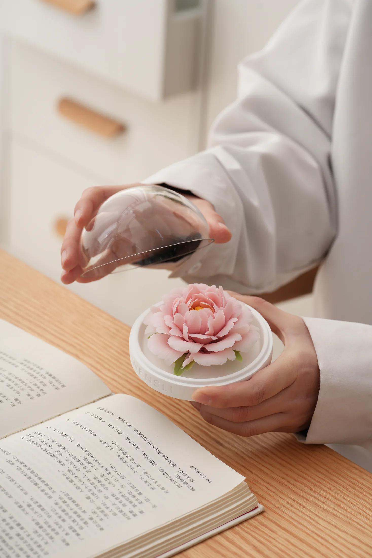 A porcelain peony fragrance flower held in its presentation case